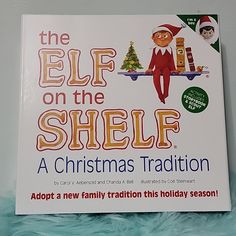 the elf on the shelf a christmas tradition book with an ornament hanging from it