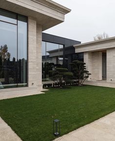 an empty lawn in front of a modern house