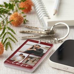 a personalized photo and text keychain is shown next to a cell phone