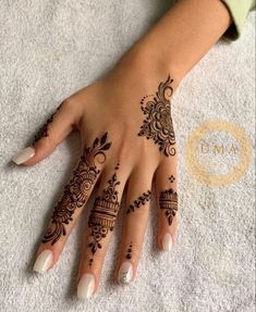 a woman's hand with henna tattoos on it