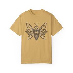 Looking for to get comfy and show off your love of nature at the same time? Look no further than this nature-inspired Honey Bee t-shirt. As part of our Comfort Colors collection, we think you will find it not only stunning to wear, but super soft and comfy too. Stand out from the crowd in this beautiful shirt that will also make the perfect gift for the nature lover in your life! Comes in multiple colors! ✨ SIZE AND FIT: Your shirt will be printed on a high-quality, soft and comfortable unisex t-shirt. Sizes run true to size, which takes the guesswork out of ordering. If you like your t-shirts loose or oversized - size up. For a more fitted women's style - size down. If you are looking for the 'shirt dress' look you see in some of the photos, size up 2 or 3 sizes. Please refer to our size Relaxed Fit T-shirt With Plants Print, Outdoor Cotton Printed Tops, Printed Cotton Tops For Outdoor, Nature-inspired Relaxed Fit Short Sleeve Tops, Nature-inspired Graphic Print Crew Neck Top, Nature-inspired Cotton Tops With Screen Print, Nature-inspired Relaxed Fit Short Sleeve T-shirt, Relaxed Fit Nature-inspired Short Sleeve T-shirt, Nature-inspired Crew Neck Tops With Screen Print