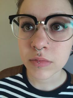 a woman wearing glasses and nose piercings