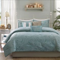 a bed with blue comforters and pillows in a room