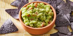 a bowl filled with guacamole surrounded by tortilla chips