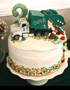 a birthday cake decorated to look like a garbage truck with the number six on top