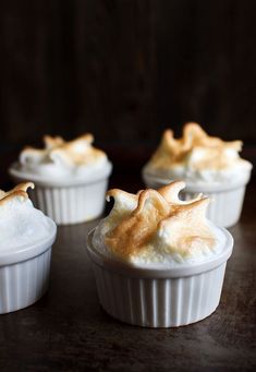 four dessert cups with meringue and whipped cream