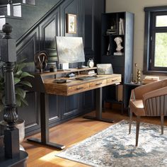 a home office with black walls and wooden floors