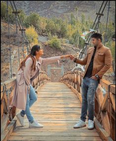 two people standing on a bridge pointing at each other