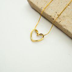 Enhance your elegance with our exquisite gold-colored necklace featuring a heart-shaped pendant. This stunning piece effortlessly combines simplicity with sophistication, making it a perfect accessory for any occasion. ✨ Unique Features: 🌟 Heartfelt Design: The pendant showcases a simple, open-heart design with smooth, rounded edges that symbolizes love and grace. 🌟 Elegant Chain: Comes with a fine, gold-colored snake chain that adds a touch of luxury to any outfit. 🌟 Versatile Charm: Perfect Gold Minimalist Open Heart Charm Necklace, Minimalist Gold Open Heart Charm Necklace, Gold Minimalist Open Heart Necklace, Minimalist Open Heart Necklace With Adjustable Chain, Minimalist Gold Plated Open Heart Necklace, Minimalist Gold Open Heart Necklace, Minimalist Gold-plated Charm Necklace With Heart Charm, Minimalist Gold-plated Heart Pendant Charm Necklace, Minimalist Gold-plated Heart Charm Necklace