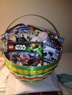 a basket filled with toys on top of a white table next to a pile of books