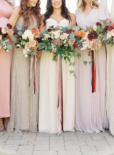 the bridesmaids are all wearing different colored dresses and holding bouquets in their hands