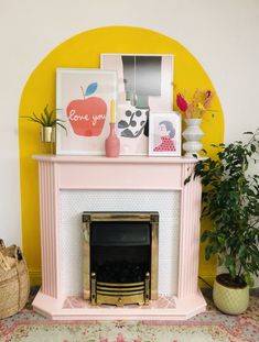 a living room with a pink fireplace and pictures on the mantle