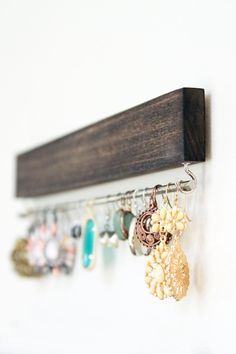 there is a wooden rack with earrings hanging from it