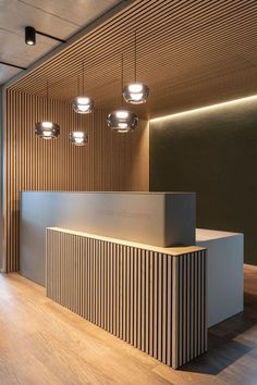 an empty reception area with wooden paneling and lights hanging from the ceiling above it