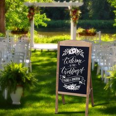 a chalkboard sign in front of rows of white chairs with flowers and greenery