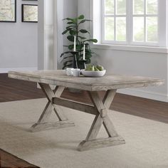 a wooden table sitting on top of a rug in a living room next to a window