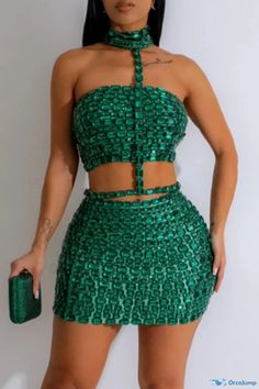 a woman in a green dress posing for the camera with her hands on her hips