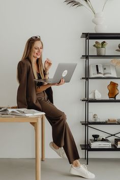 a woman sitting on a table using a laptop computer