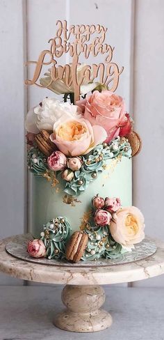 a birthday cake decorated with flowers and cookies