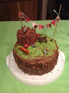 a cake that is sitting on top of a white plate with green grass and decorations