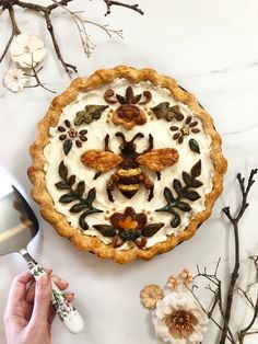 someone is decorating a pie with flowers and leaves