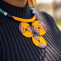 This handmade African necklace is the ultimate statement piece. Made with traditional Maasai beads, these bright and beautiful pieces will add the perfect finishing touch to any outfit. The clasp is made of brass and is a simple, comfortable design.  Made by women from the Maasai community in Kajiado County, Kenya.  These are traditionally worn by individuals of any gender. In East Africa, every beaded ornament we adorn tells a story and we're proud to tell our stories about our culture. We also embrace and appreciate individuals from other cultures who share in our love for these beautiful and brightly beaded pieces! Traditional Yellow Beaded Necklace, Traditional Yellow Beaded Necklace For Gift, Traditional Yellow Jewelry, Traditional Yellow Beads For Gift, Traditional Yellow Beads For Crafting, Handmade Vibrant Yellow Necklace, Traditional Yellow Round Beaded Necklaces, Vibrant Handmade Beaded Necklace For Gift, Masai Jewelry