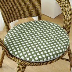 a wicker chair with a green and white checkered seat pad on it's back