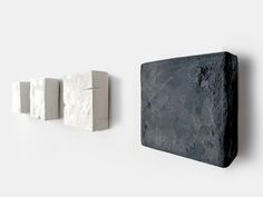 three stone blocks are hanging on the wall