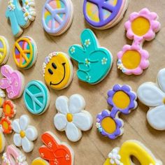 some decorated cookies are laying out on a table with flowers and peace signs in the middle