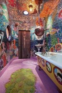 this bathroom has colorful walls and floors with lots of artwork on the walls, along with a large bathtub