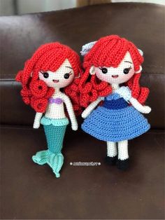 two crocheted little mermaid dolls sitting next to each other on a brown couch