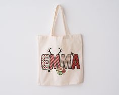 an embroidered tote bag with the word'ema'in red and black