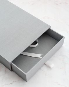 a pair of scissors sitting inside of a gray box