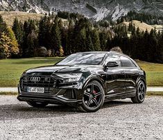 an audi suv parked in front of a mountain