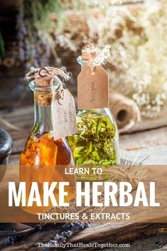 two bottles filled with liquid sitting on top of a wooden table next to flowers and herbs