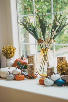 a vase filled with flowers sitting on top of a window sill next to rocks