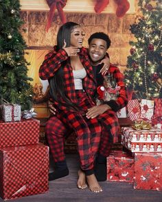 a man and woman dressed in plaid pajamas posing for a christmas photo