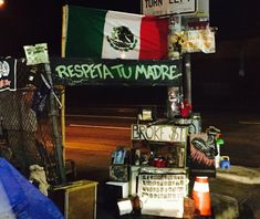 there are many signs on this street pole that say resta tu madre and mexican flag