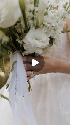 a woman holding a bouquet of white flowers