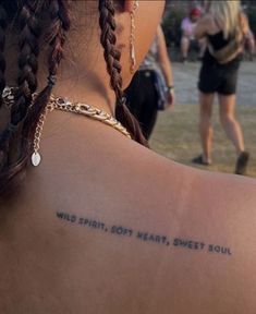 a woman with a tattoo on her back saying wild spirit, bolt heart sweet soul