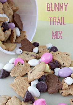 a bowl full of bunny trail mix next to a cup filled with marshmallows