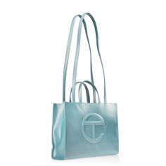 Brand New New Color Alert : Blue Ray Iconic Unisex Shopping Bag Is An Everyday Bag For Everyone. Featuring A Double Strap (Handles And Cross-Body Straps), Embossed Logo, A Main Compartment With Magnetic Snap Closure And Internal Zipper Pocket. Made From Faux Leather And Twill Lining. Bag Is Packaged In A Drawstring Bag With Screen-Printed Logo. Medium Fits A Laptop + Your Daily Survival Kit. Materials 50% Polyurethane, 50% Polyester Dimensions Height 11 1/4", Width 15", Depth 5", Strap Drop 21", Blue Shoulder Bag For Shopping With Dust Bag, Designer Light Blue Shopping Bag, Designer Light Blue Shoulder Bag For Shopping, Light Blue Shopping Bag, Light Blue Tote Bag For Evening, Light Blue Evening Tote Bag, Modern Light Blue Shoulder Bag For Shopping, Telfar Shopping Bag, Body Straps