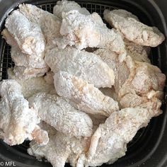 chicken wings are cooked in an air fryer with some powdered sugar on top