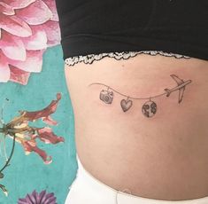 a woman's stomach with an airplane and hearts tattoo on her lower side ribcage