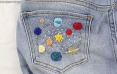 the back pocket of someone's jeans with different colored patches and buttons on them