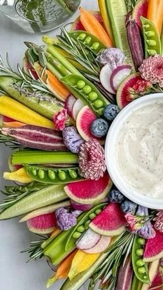 a wreath made out of vegetables and dip