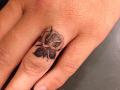 a woman's hand with a rose tattoo on it