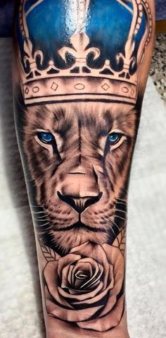 a lion with a crown on his head and blue eyes is shown in this tattoo