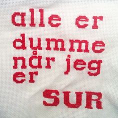 a white towel with red lettering on it that says, alle er dumme nor jeg er sun