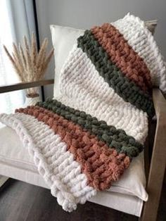 a crocheted blanket sitting on top of a white chair